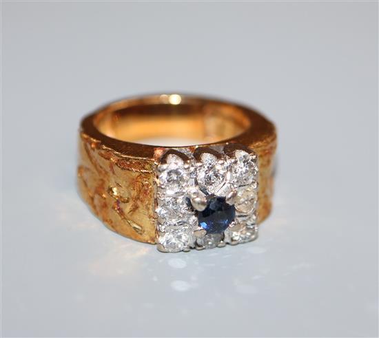 A 1970s? textured yellow metal, sapphire and diamond cluster ring, size H.